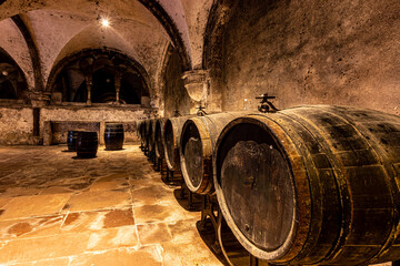  woodenbarrows of wine in the basement of a winery