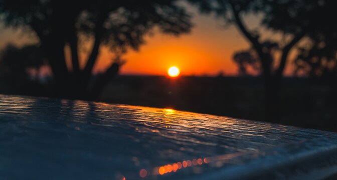 Closeup shot of a wet surface on a sunset background