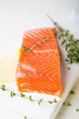 A piece of smoked salmon with thyme and lemon
