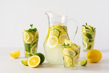 Summer refreshing drink of lemon, lime and mint, jug with lemonade and glasses and citrus slices