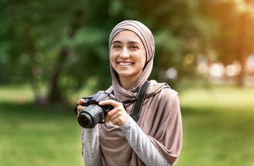 Portrait of beautiful muslim woman photographer with digital camera