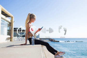 Young female jogger enjoying rest after workout while checking results of training on mobile phone application. Fit woman calculating expended kilocalories on cellular. Infographics fit app interface