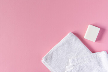White towel with soap on a pink background, bath spa accessories