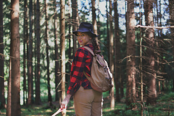 Young woman on a walk outdoors in forest in summer nature.