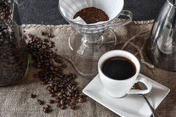 hot delicous white cup of coffee - made with grounded coffe beans and a hand filter