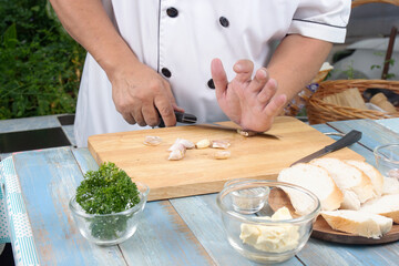 Chef chopping garlic for cooked Garlic bread