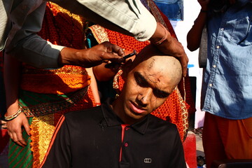 Almora, uttrakhand / India - May 26 2020 : A close of a hand and a head while cutting hairs, indian...