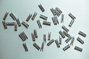 A lot of small clothespins on a white background, in black and white.