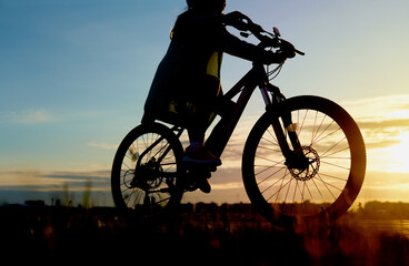 Girl is cycling road bike in the sunset A young girl is cycling into the sunset in the park...
