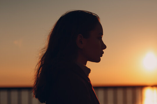 Young beautiful woman profile portrait at sunset.