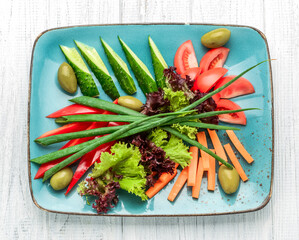 Different sliced fresh vegetables on a color plate