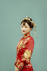 Asian girl in ancient red dress holding fan in green background