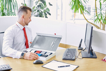 Naklejka premium young professional salesman represents a color palette to buyers,consult them and help with choice