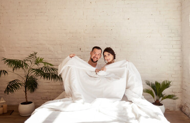 man and woman joke in the morning in bed