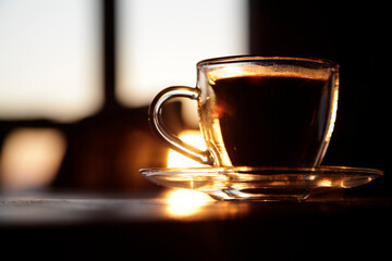 cup of coffee on the table at sunset