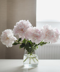 Beautiful pink peonies in a vase at home interior. Flower composition. Floral shop concept. Beautiful fresh cut bouquet. copyspace