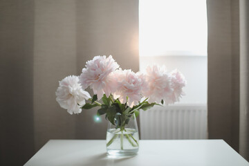 Beautiful pink peonies in a vase at home interior. Flower composition. Floral shop concept....