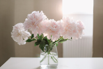 Beautiful pink peonies in a vase at home interior. Flower composition. Floral shop concept. Beautiful fresh cut bouquet. copyspace