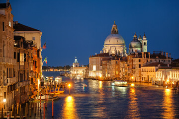 Fototapeta na wymiar View of Venice Grand Canal with boats and Santa Maria della Salute church in the evening from Ponte dell'Accademia bridge. Venice, Italy