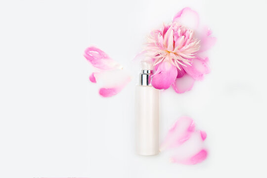 Natural cosmetics, mock up. Jar of cream and pink peony in a milk bath. Conceptual photo: the best cosmetic tool for body and face care. Gentle care. Copy space, flat lay.