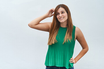 Young woman making the gesture of thinking isolated on a white background.