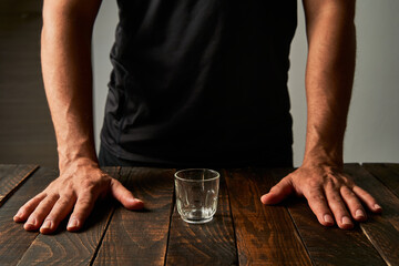 Fototapeta na wymiar Man at a bar with a shot glass. Concept of alcoholism and addiction.