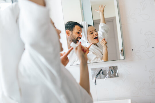 Young Couple Having Fun And Singing In Bathroom