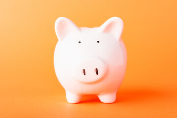 Front small white fat piggy bank, studio shot isolated on orange background and copy space for use, Finance, deposit saving money concept