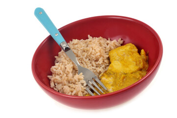 Repas diététique avec du poisson au curry avec du riz servis dans une assiette sur fond blanc
