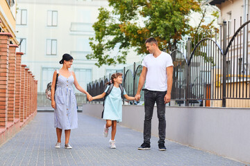 Family and schoolgirl with a backpack way to school