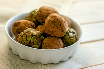 Raw food sweets handmade balls of seeds, nuts, dates and coconut, close-up