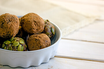 Raw food sweets handmade balls of seeds, nuts, dates and coconut, close-up