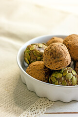 Raw food sweets handmade balls of seeds, nuts, dates and coconut, close-up