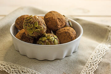 Raw food sweets handmade balls of seeds, nuts, dates and coconut, close-up