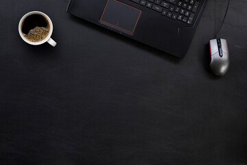 top view of office desk workspace with coffee cup and laptop  on black table background. flat lay