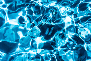 Repeating summer pattern of photographed, living water surfaces in a pool, with the emphasis on light refraction where you can see the sprinkled ground moving along with the waves