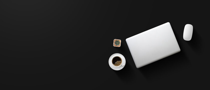 top view of office desk workspace with coffee cup and laptop on black table background. flat lay