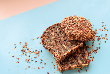 Sliced whole grain bread rye with seeds flax, sunflower, pumpkin and sesame.Healthy food, eco-friendly natural products. Fresh bread on a pink background.
