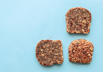 Sliced whole grain bread rye with seeds flax, sunflower, pumpkin and sesame.Healthy food, eco-friendly natural products. Fresh bread on a pink background.