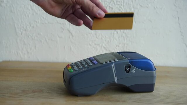 cropped view of man applying credit card and pushing buttons on payment terminal