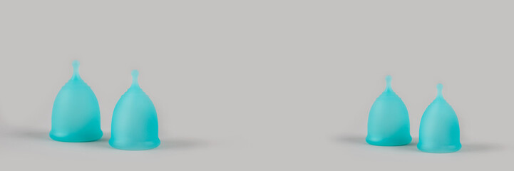 Banner with set of blue menstrual cups on grey background with copyspace for text or creative presentation. Women health and zero waste concept. Female hygiene period products or alternative lifestyle