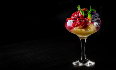 fruit sorbet ice cream in a glass bowl on black wooden table background