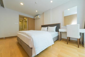 Fototapeta na wymiar White pillows on wooden bed in minimal bedroom interior