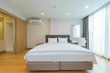 Fototapeta na wymiar White pillows on wooden bed in minimal bedroom interior