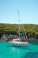 White yacht sailing in the turquoise lagoon on a sunny day