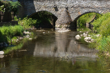 Fototapeta na wymiar Old stone bridge over the Elzbach creek in Monreal / Germany in the Eifel