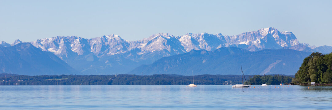 Panorama of Lake Starnberg with Zugspitze and Wetterstein mountain range in the background.
