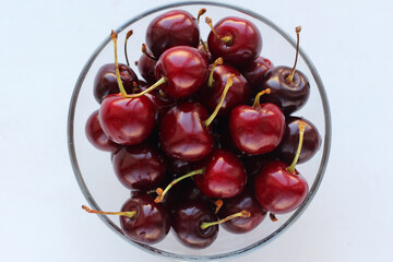 Juicy sweet cherries in a glass bowl isolated on white