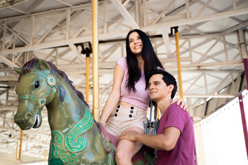 Obraz na płótnie Canvas Couples play carousel while visiting an amusement park.