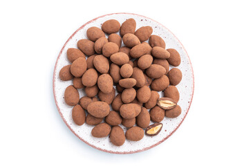 Almond in chocolate dragees on ceramic plate isolated on white background. Top view.